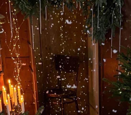 Tunnelmallinen joulukuvausmiljöö, joulukuusia ja luistimet ripustettuna naulaan.